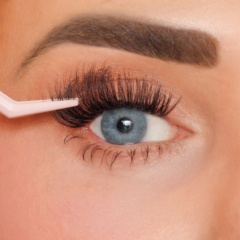 Eyelash extension application process with a close-up of an eye.