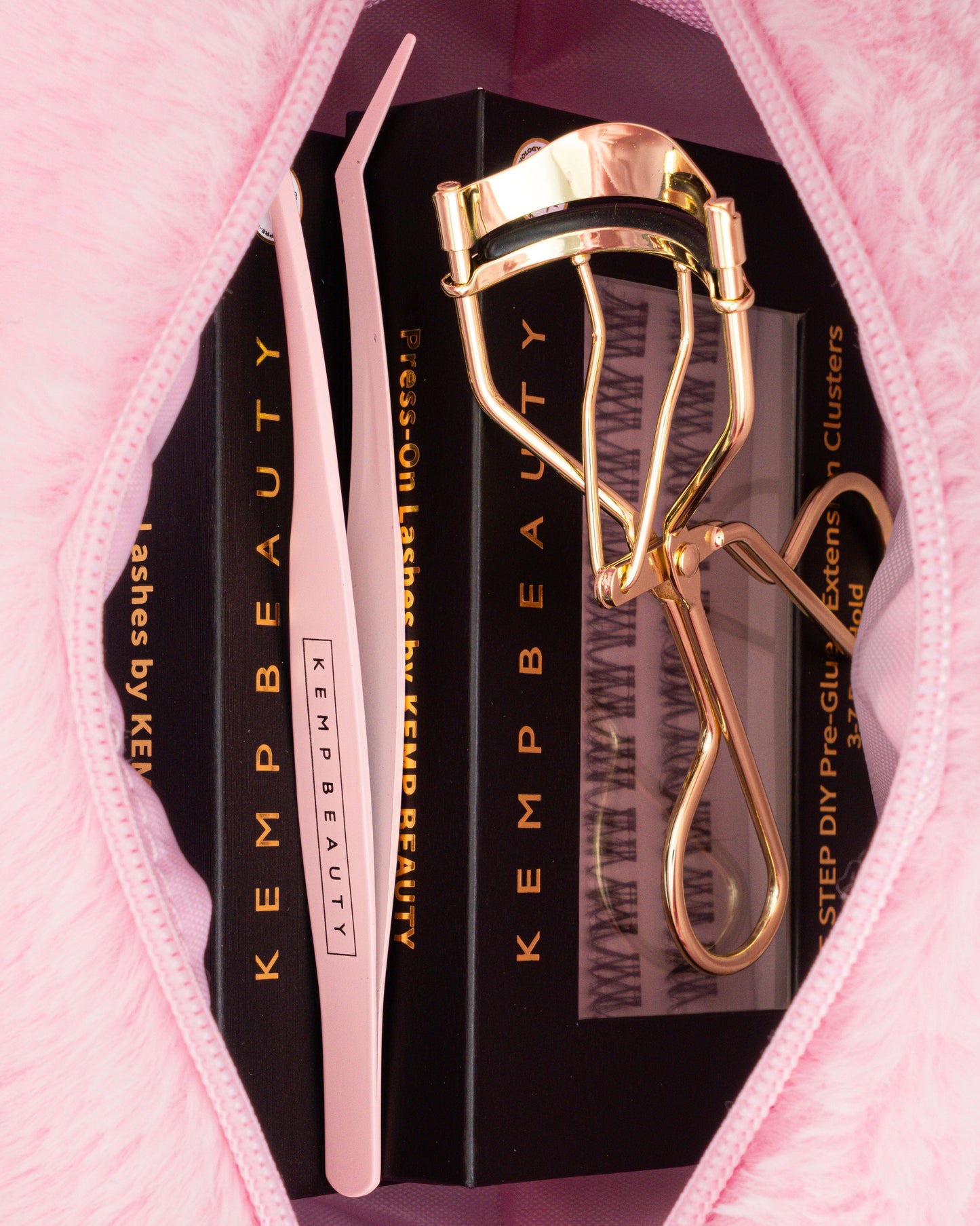 Open Kemp Beauty travel bag with curler, tweezers, and lash cluster box inside