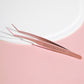 Eyelash curler and applicator tweezer tool included in the kit, styled on satin