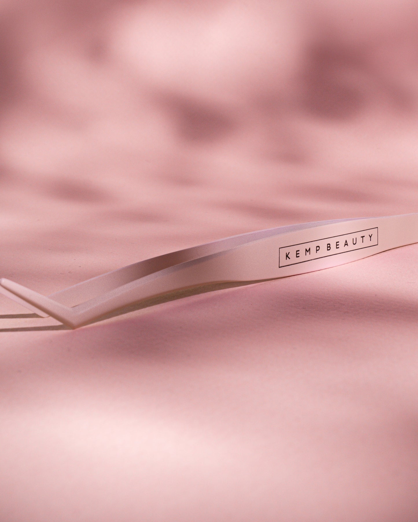 Kemp Beauty applicator tweezer tool styled on satin