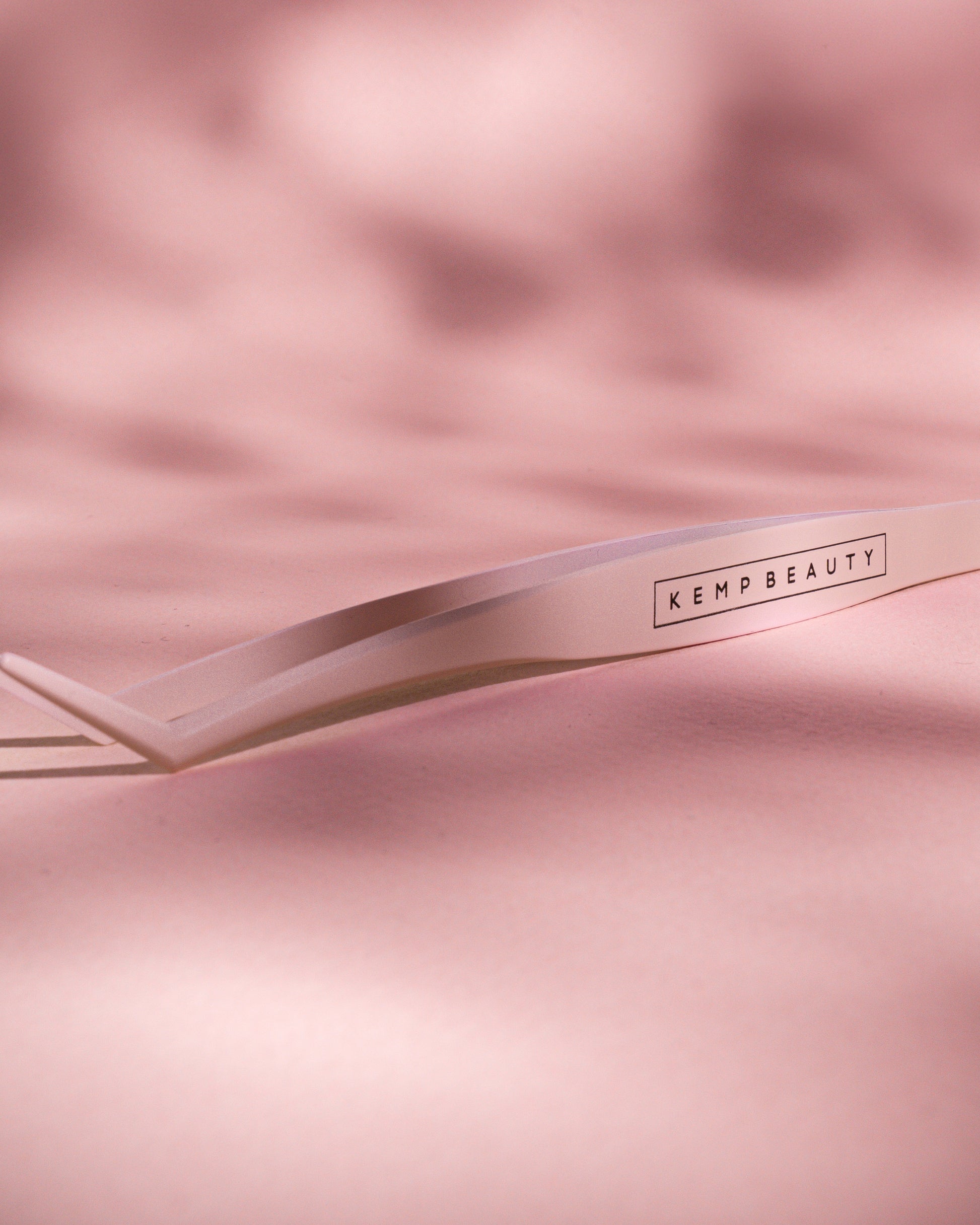 Kemp Beauty applicator tweezer tool styled on satin