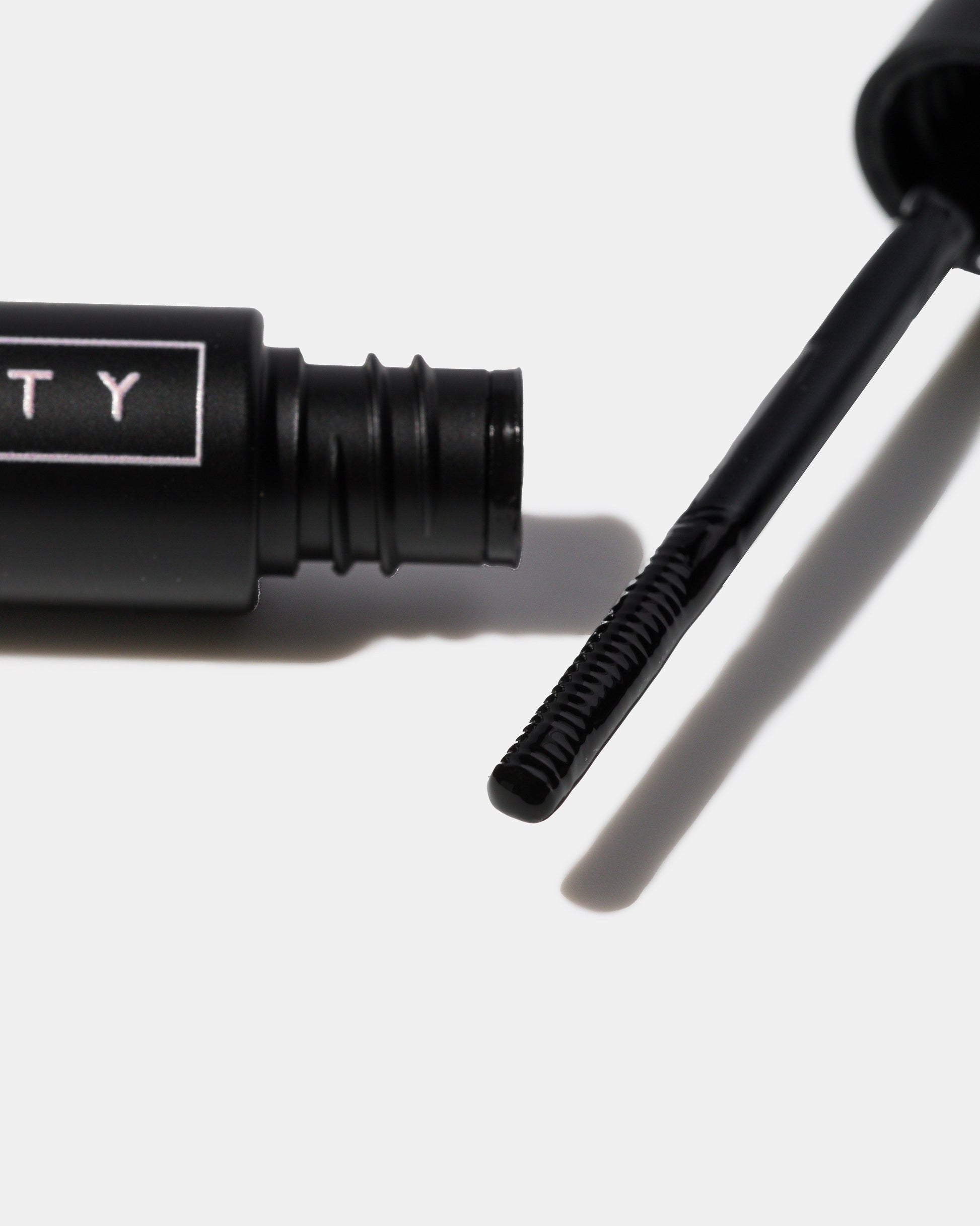 Eyelash serum with applicator on a white background